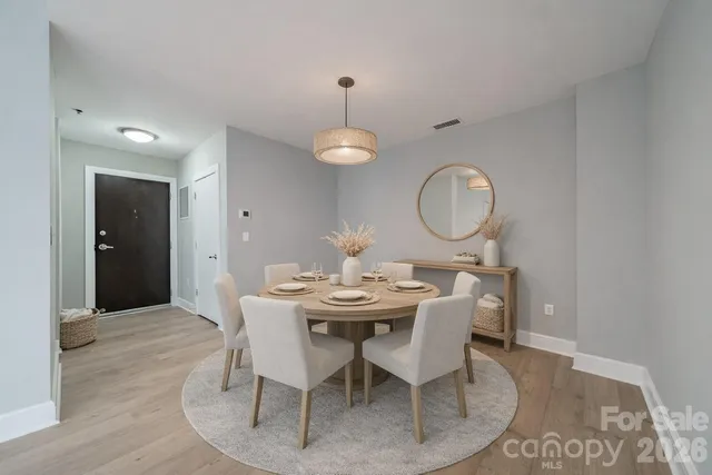 a dining room with livingroom view and wooden floor