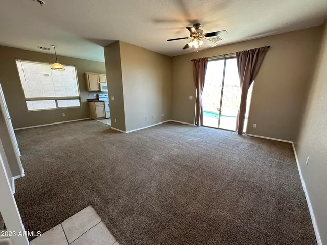 an empty room with windows and fan