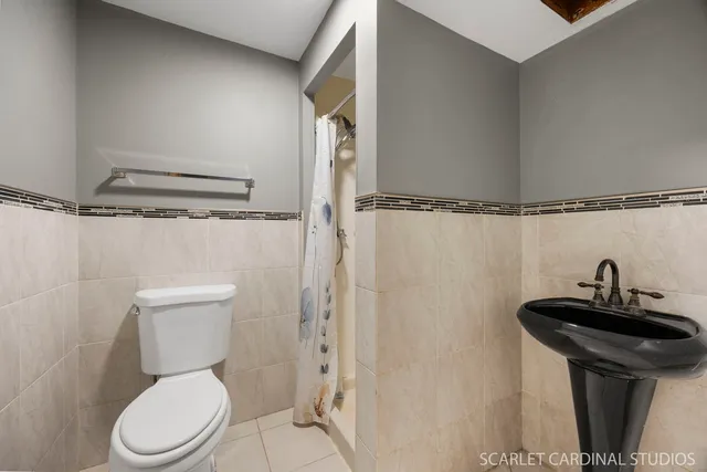 a bathroom with a sink a toilet a mirror and shower