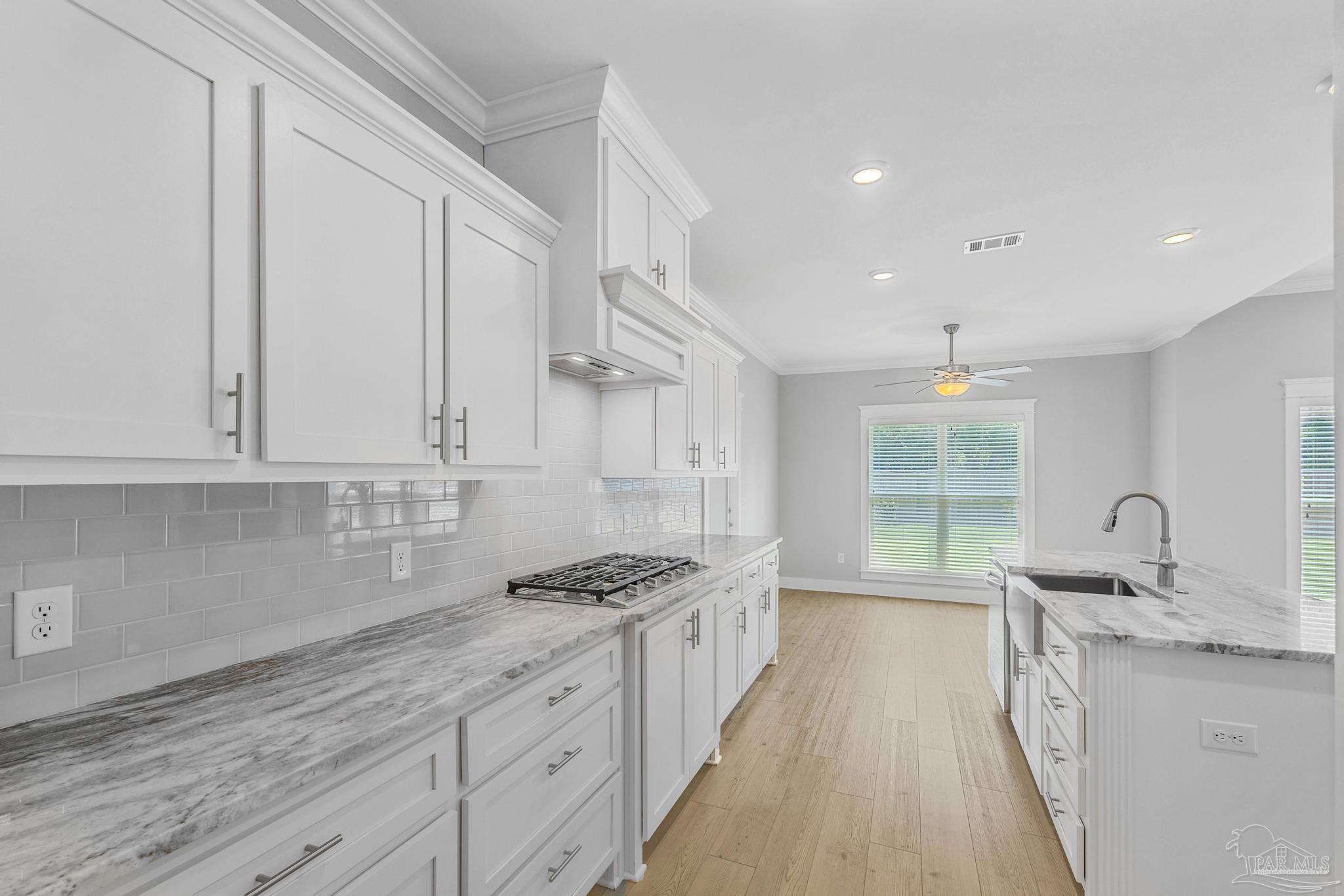 6264 Howie Way Pace, FL 32571 - Photo 13 of 42 a kitchen with granite countertop a sink stove and cabinets