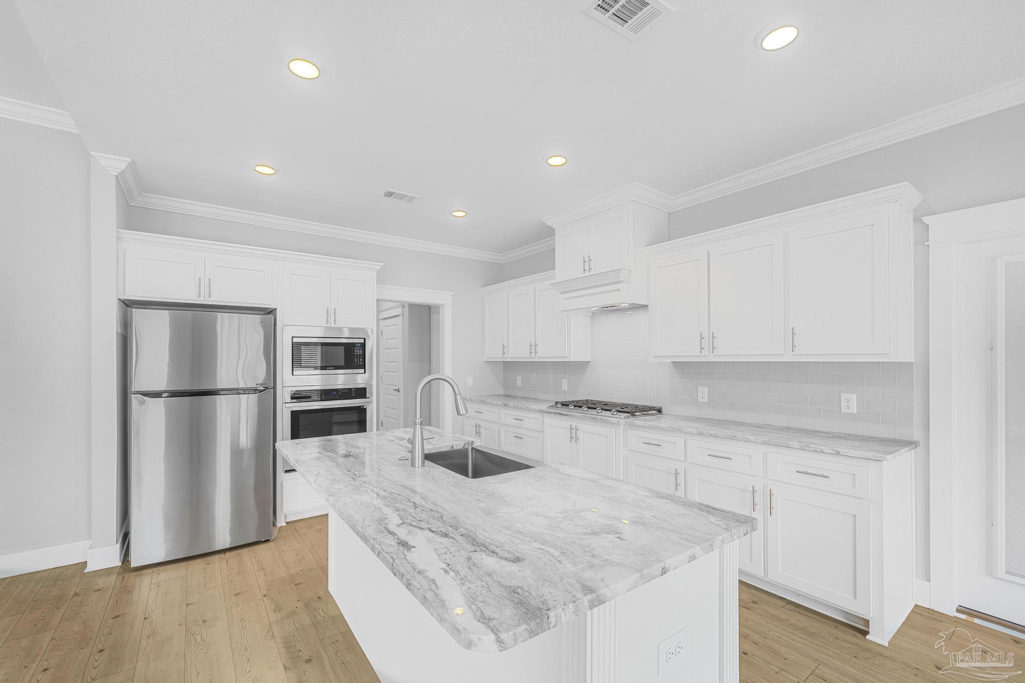 6264 Howie Way Pace, FL 32571 - Photo 3 of 42 a kitchen with refrigerator and cabinets