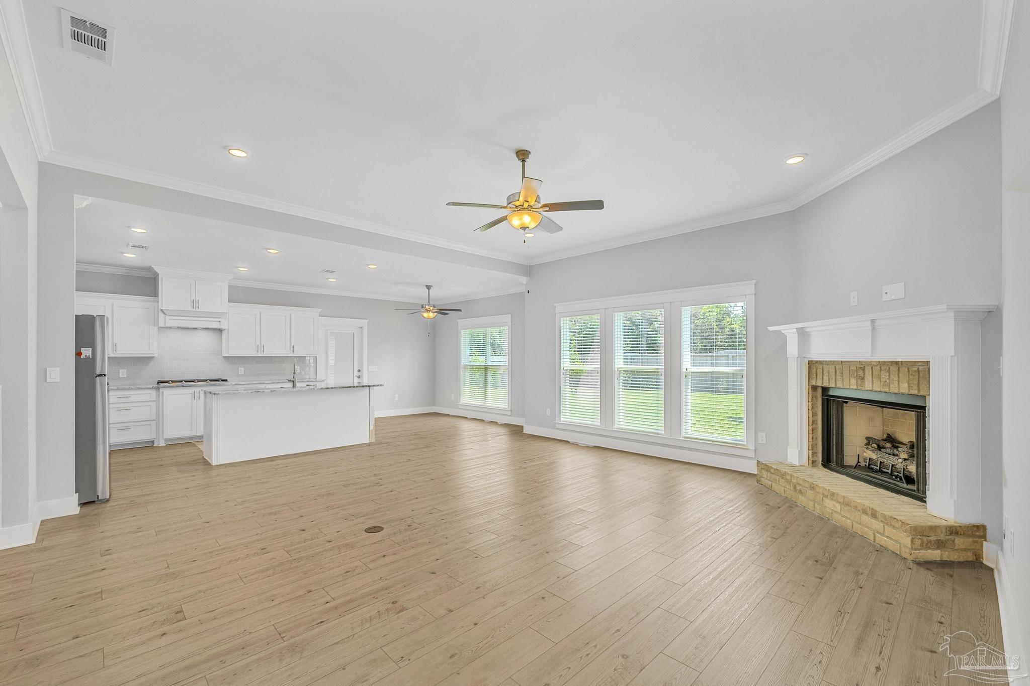 6264 Howie Way Pace, FL 32571 - Photo 4 of 42 a view of empty room with wooden floor and fireplace