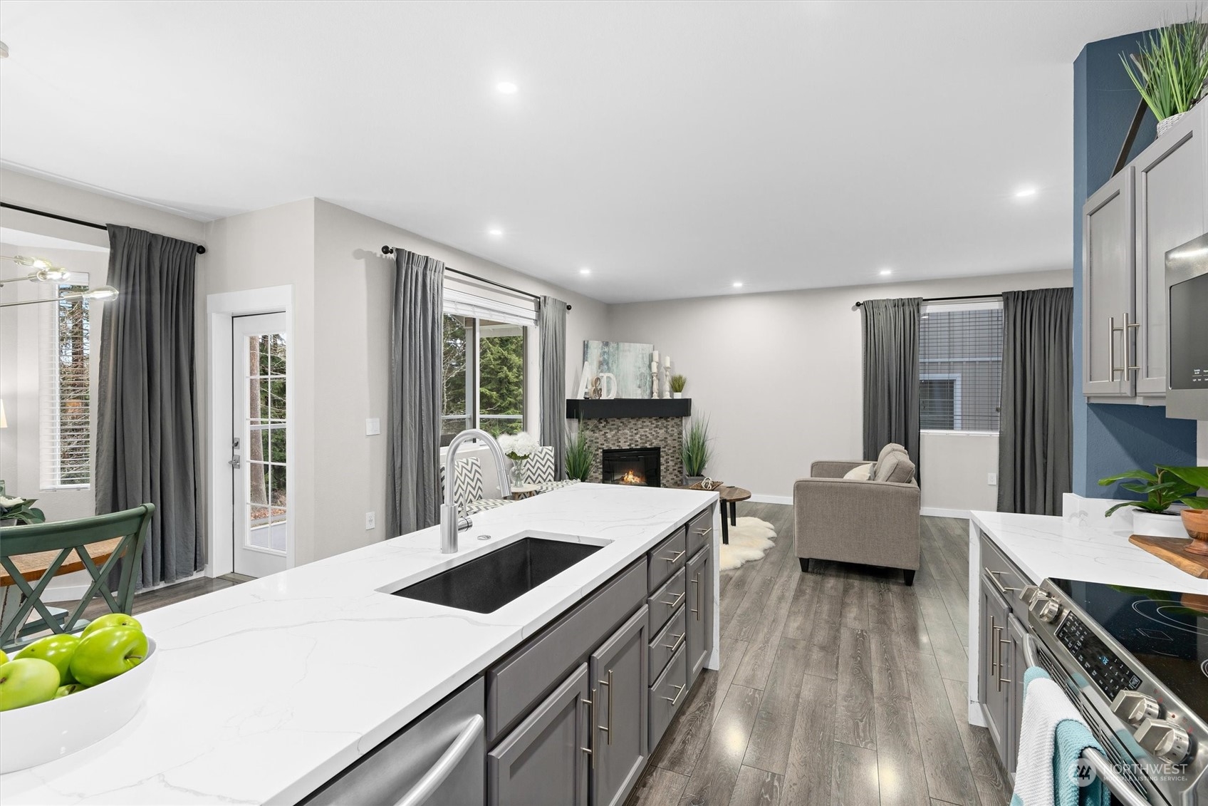 2810 Southeast 8th Street, Unit 2131 Renton, WA 98058 - Photo 6 of 35 a open kitchen with stainless steel appliances kitchen island granite countertop a refrigerator a stove and a wooden floors