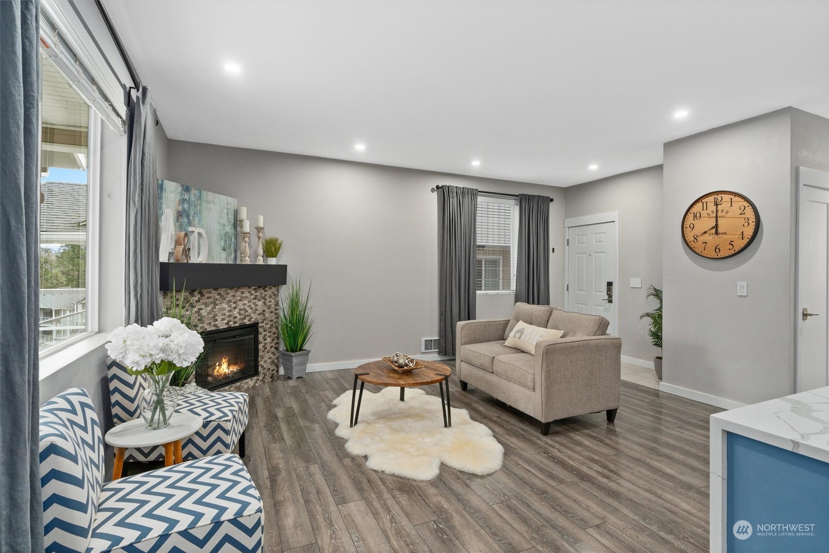 2810 Southeast 8th Street, Unit 2131 Renton, WA 98058 - Photo 9 of 35 a living room with furniture a fireplace and a table with wooden floor