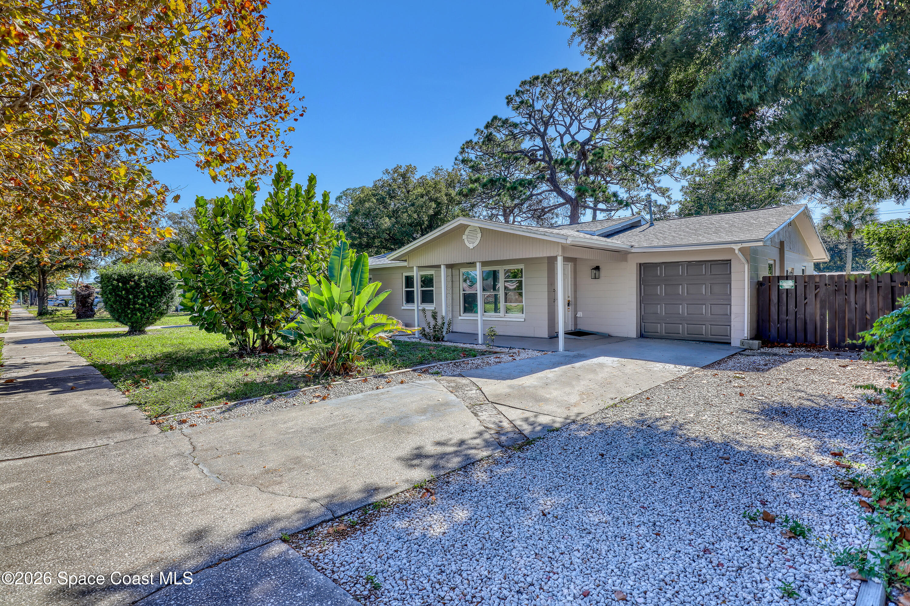 a front view of a house with yard porch and tree