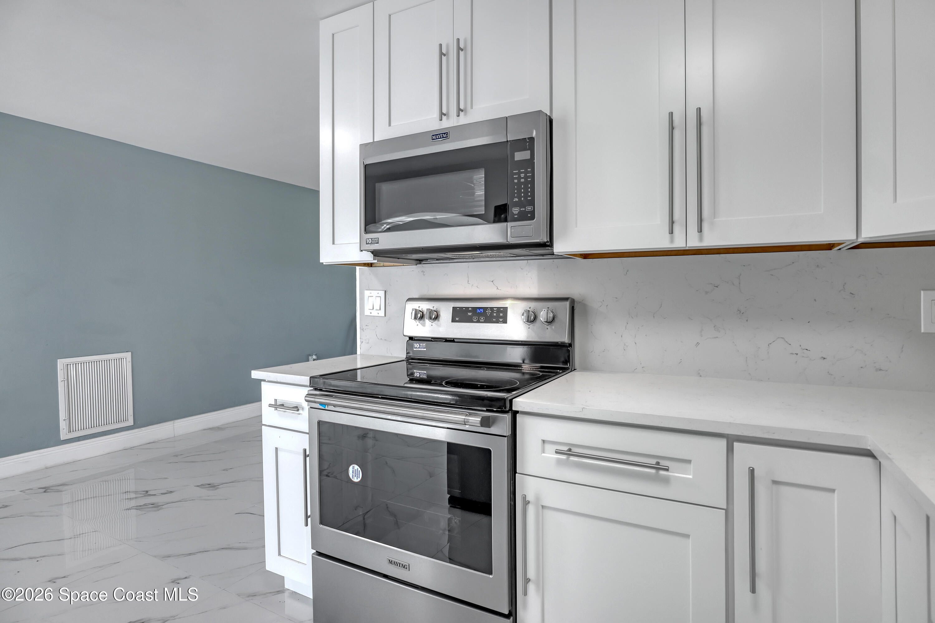 1051 Grove Avenue Cocoa, FL 32922 - Photo 12 of 38 a kitchen with cabinets stainless steel appliances and wooden floor