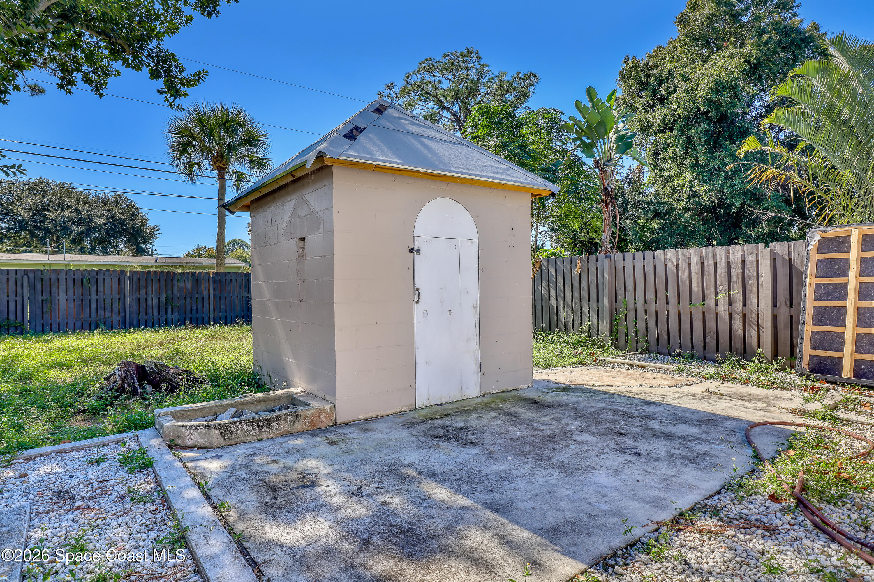 1051 Grove Avenue Cocoa, FL 32922 - Photo 32 of 38 a backyard of a house with plants and wooden fence