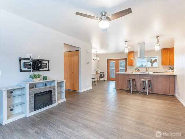 an empty room with wooden floor fireplace and staircase