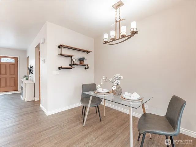 a view of a dining room with furniture a chandelier and wooden floor