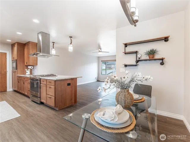 a kitchen with stainless steel appliances granite countertop a sink a stove and a wooden cabinets