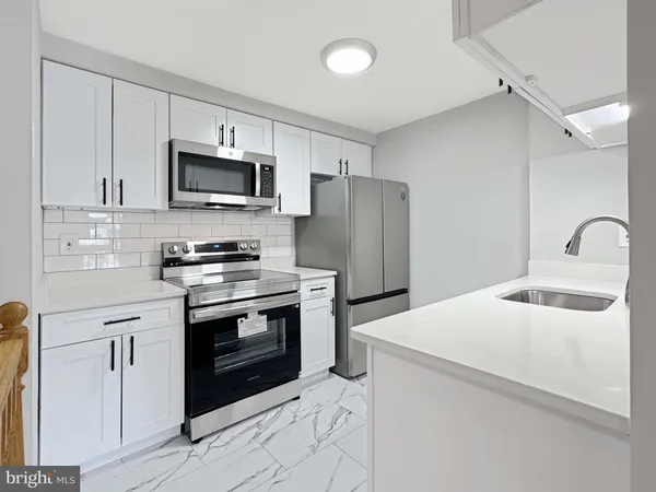 a kitchen with stainless steel appliances a stove microwave and sink