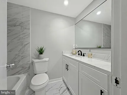 a bathroom with a toilet a sink and mirror