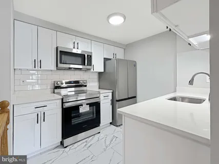 a kitchen with stainless steel appliances granite countertop a stove microwave and refrigerator