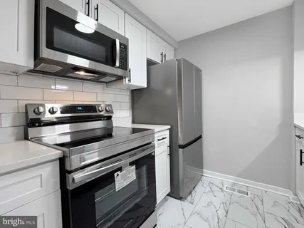 a kitchen with stainless steel appliances granite countertop a stove microwave and refrigerator