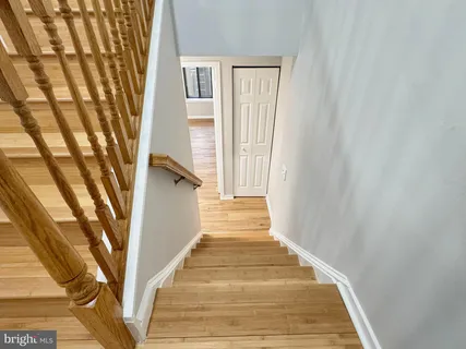 a view of a hallway with wooden floor and staircase