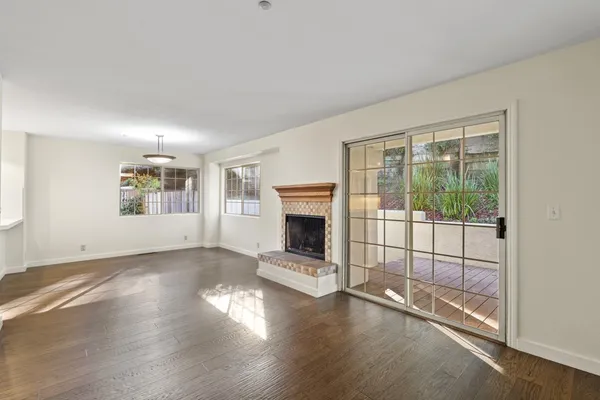 an empty room with floor to ceiling window and fireplace