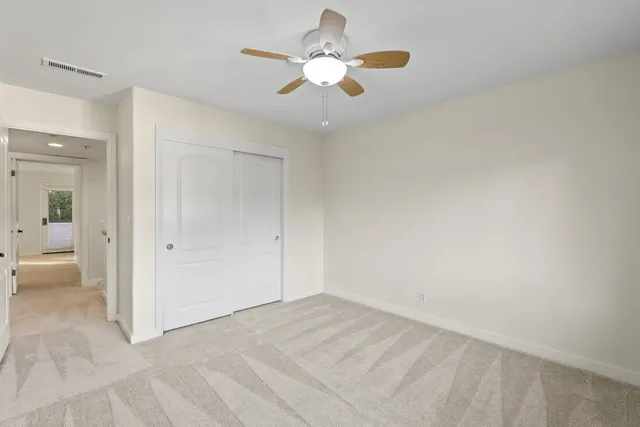 a view of an empty room and chandelier fan