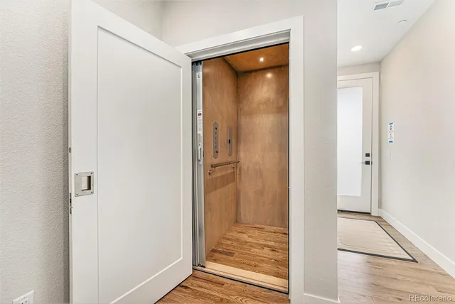 a kitchen with stainless steel appliances a refrigerator a sink a stove a dining table and chairs