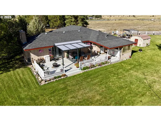 a view of a house with a garden and sitting area