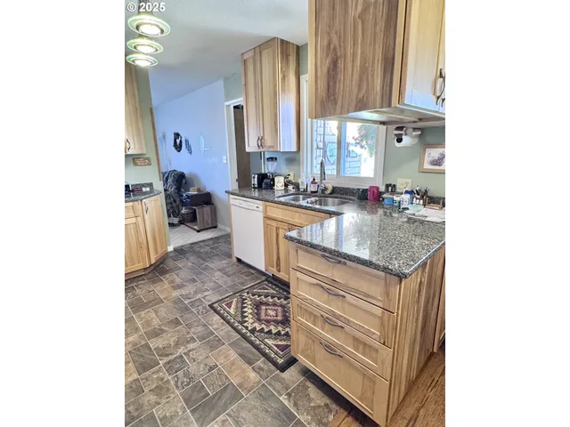 a kitchen with stainless steel appliances granite countertop a refrigerator sink and cabinets