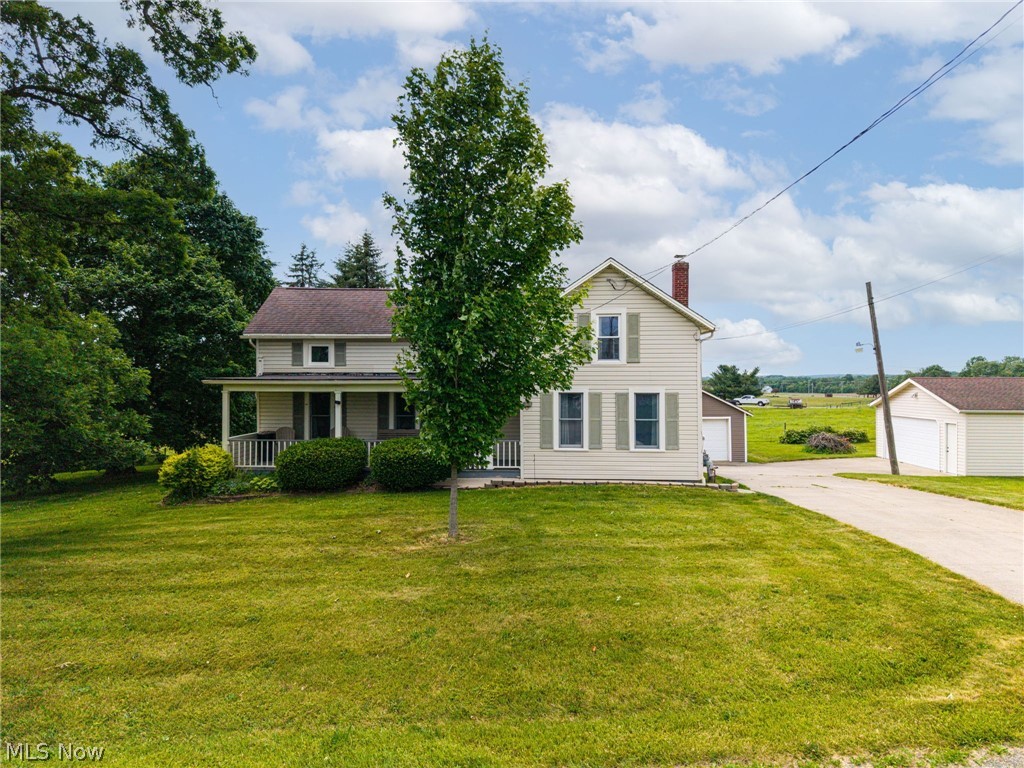 9626 Daniels Road Seville, OH 44273 - Photo 1 of 37 Cream-colored siding home featuring a covered front porch with white railings, a prominent red brick chimney, and light green window shutters