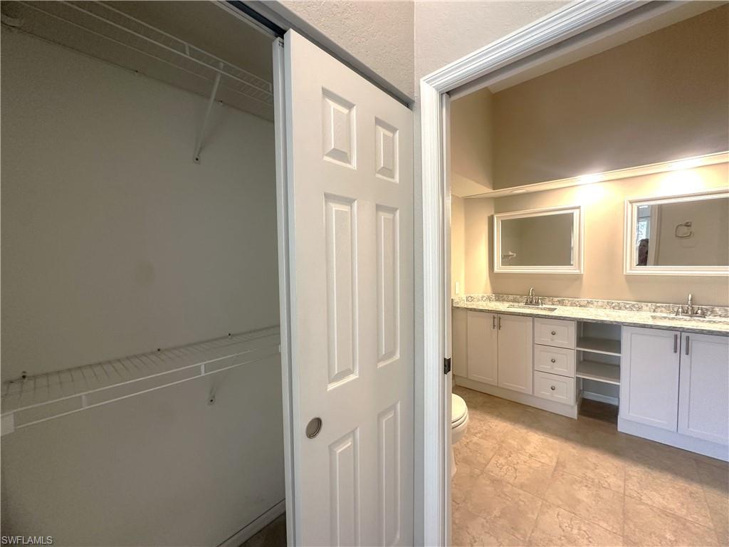 6922 Satinleaf Road North, Unit 203 Naples, FL 34109 - Photo 15 of 31 a bathroom with a sink a vanity and a mirror