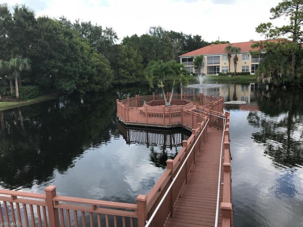6922 Satinleaf Road North, Unit 203 Naples, FL 34109 - Photo 26 of 31 a balcony of a house with wooden floor and outdoor seating