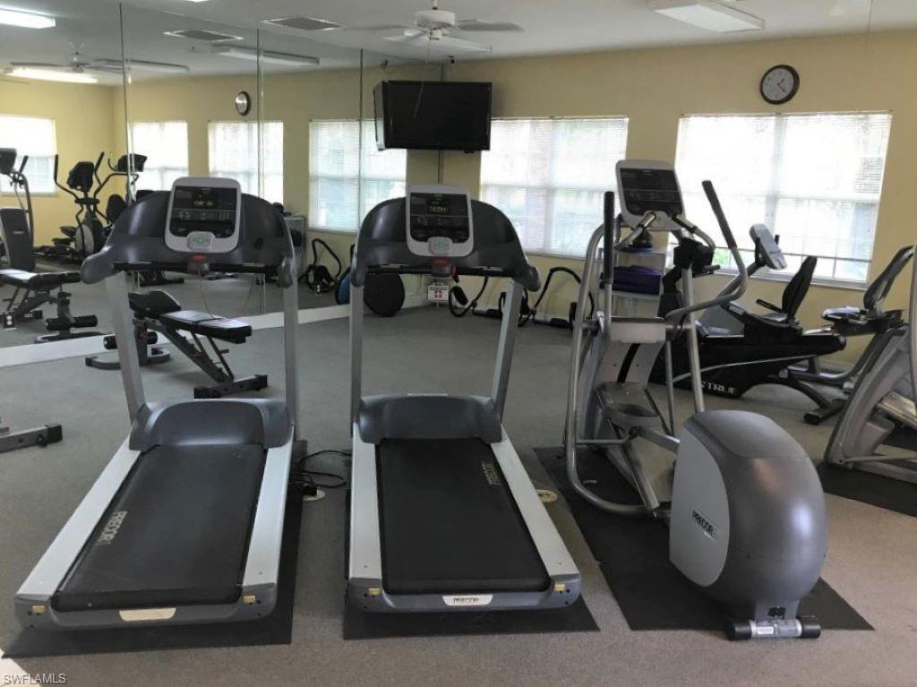 6922 Satinleaf Road North, Unit 203 Naples, FL 34109 - Photo 29 of 31 a room with gym equipment and windows