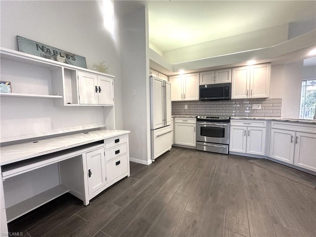 6922 Satinleaf Road North, Unit 203 Naples, FL 34109 - Photo 4 of 31 a kitchen with stainless steel appliances white cabinets a sink and a stove