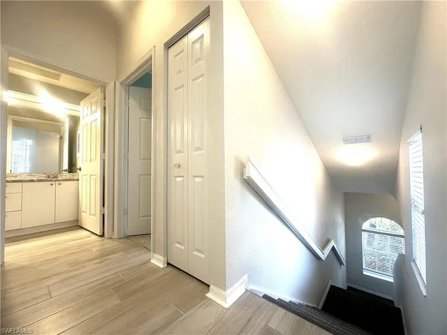 a view of a hallway with wooden floor and staircase