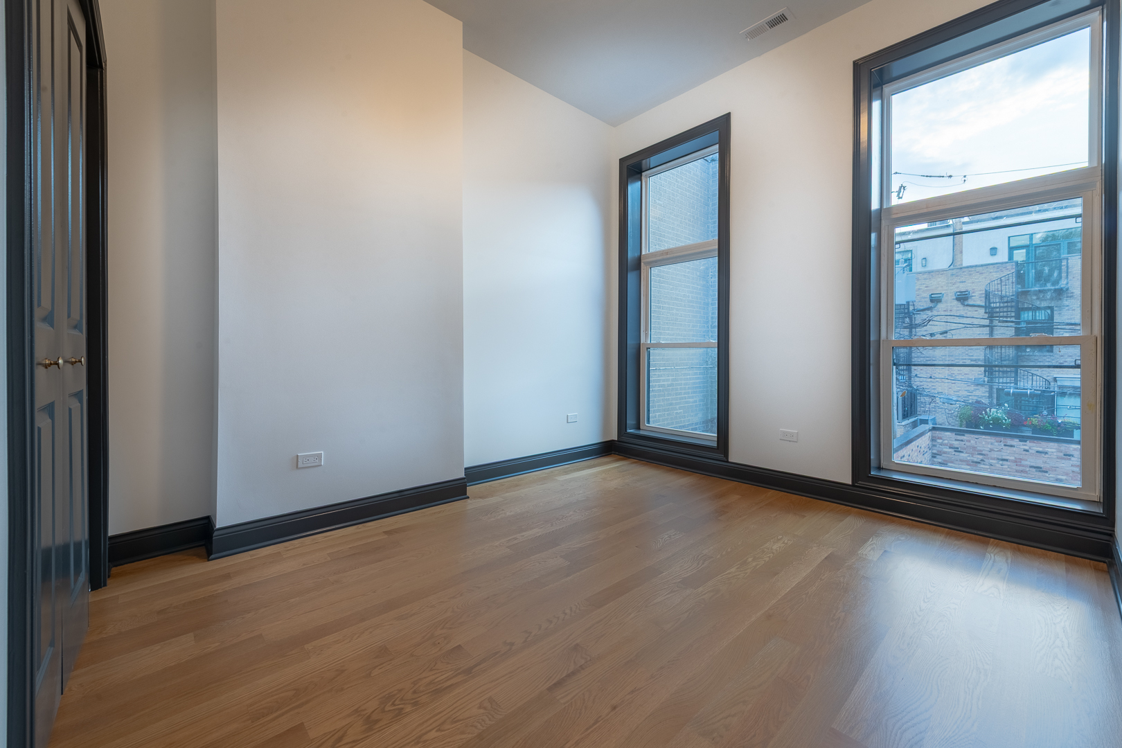 28 North Throop Street, Unit 2 Chicago, IL 60607 - Photo 25 of 35 an empty room with wooden floor and windows