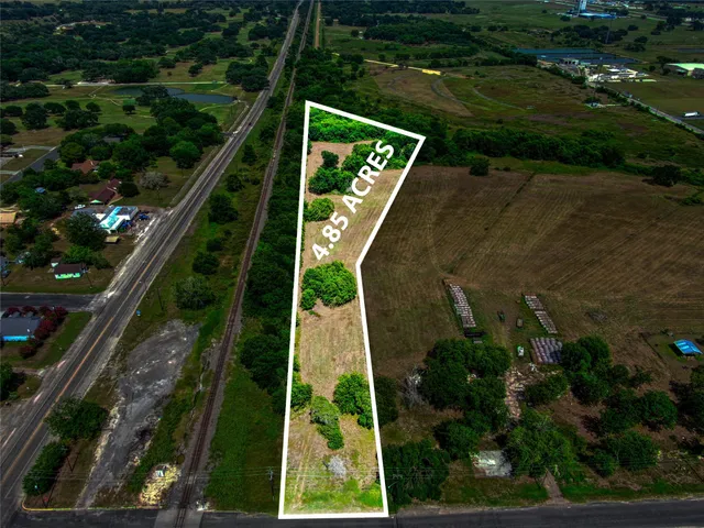 an aerial view of residential houses with outdoor space and street view