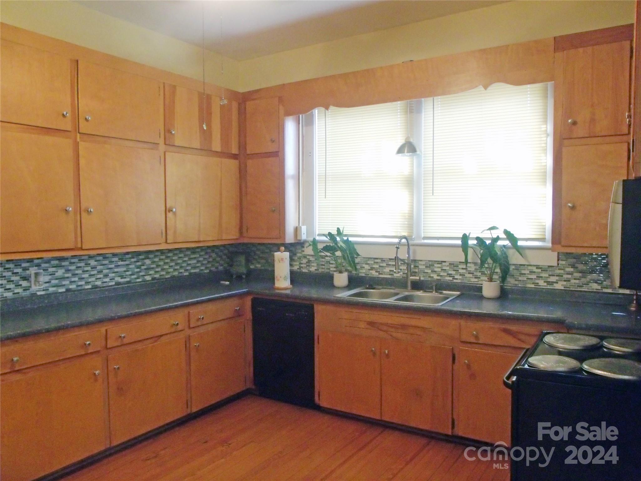 143 Lancaster Street Chester, SC 29706 - Photo 12 of 29 a kitchen with stainless steel appliances granite countertop a sink a stove cabinets and wooden floor