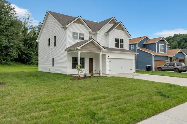 a front view of a house with a garden and yard