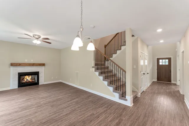a view of a livingroom with wooden floor and a fireplace