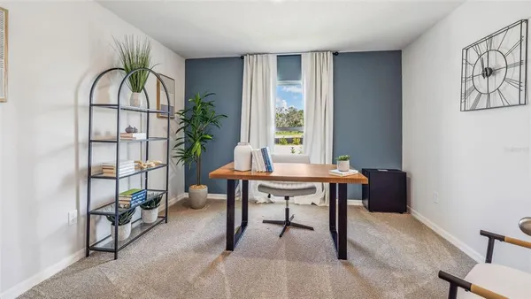 a view of a workspace room with furniture and window