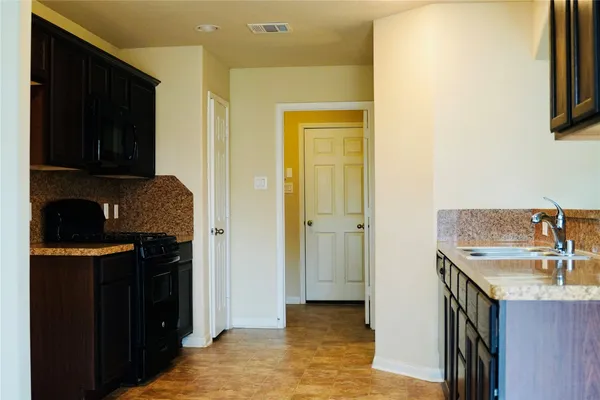 a kitchen with stainless steel appliances granite countertop a sink and a refrigerator