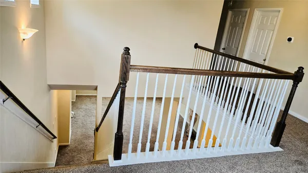 a view of staircase with railing and a rug