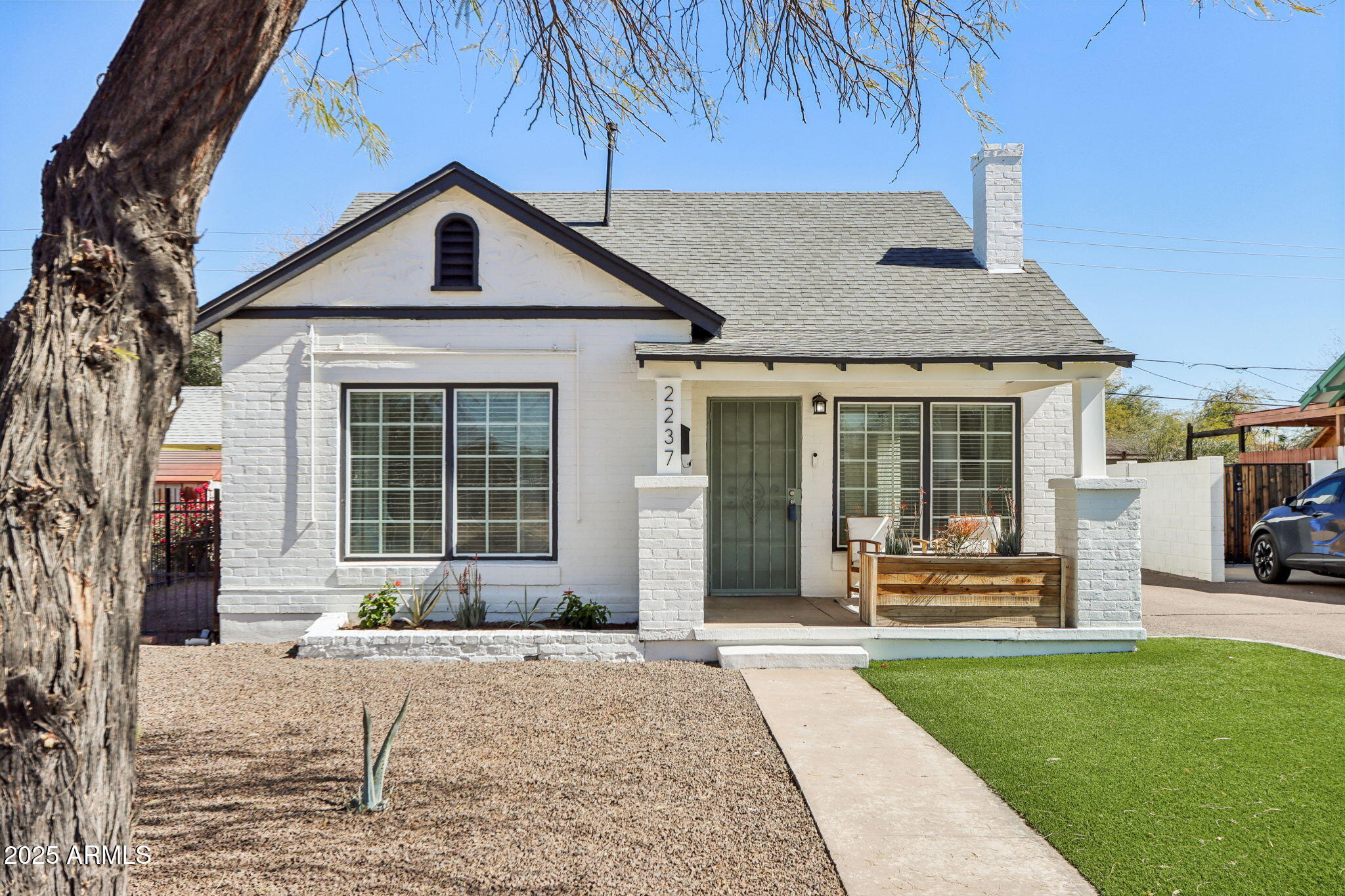 a front view of a house with a yard and potted plants