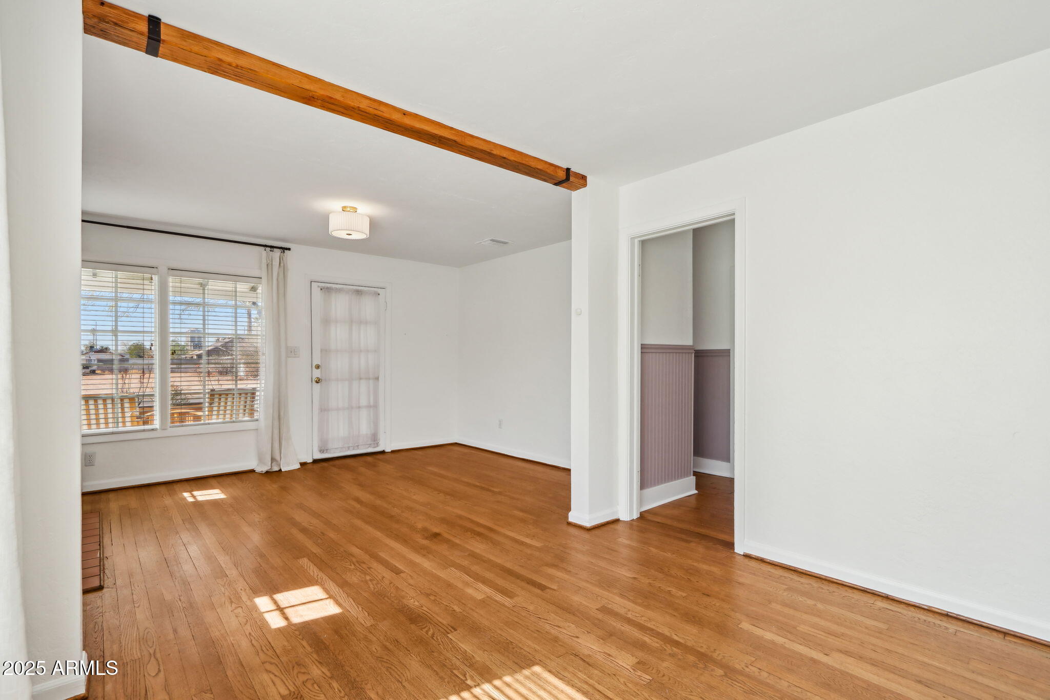2237 North 9th Street Phoenix, AZ 85006 - Photo 9 of 29 a view of an empty room with wooden floor and a window