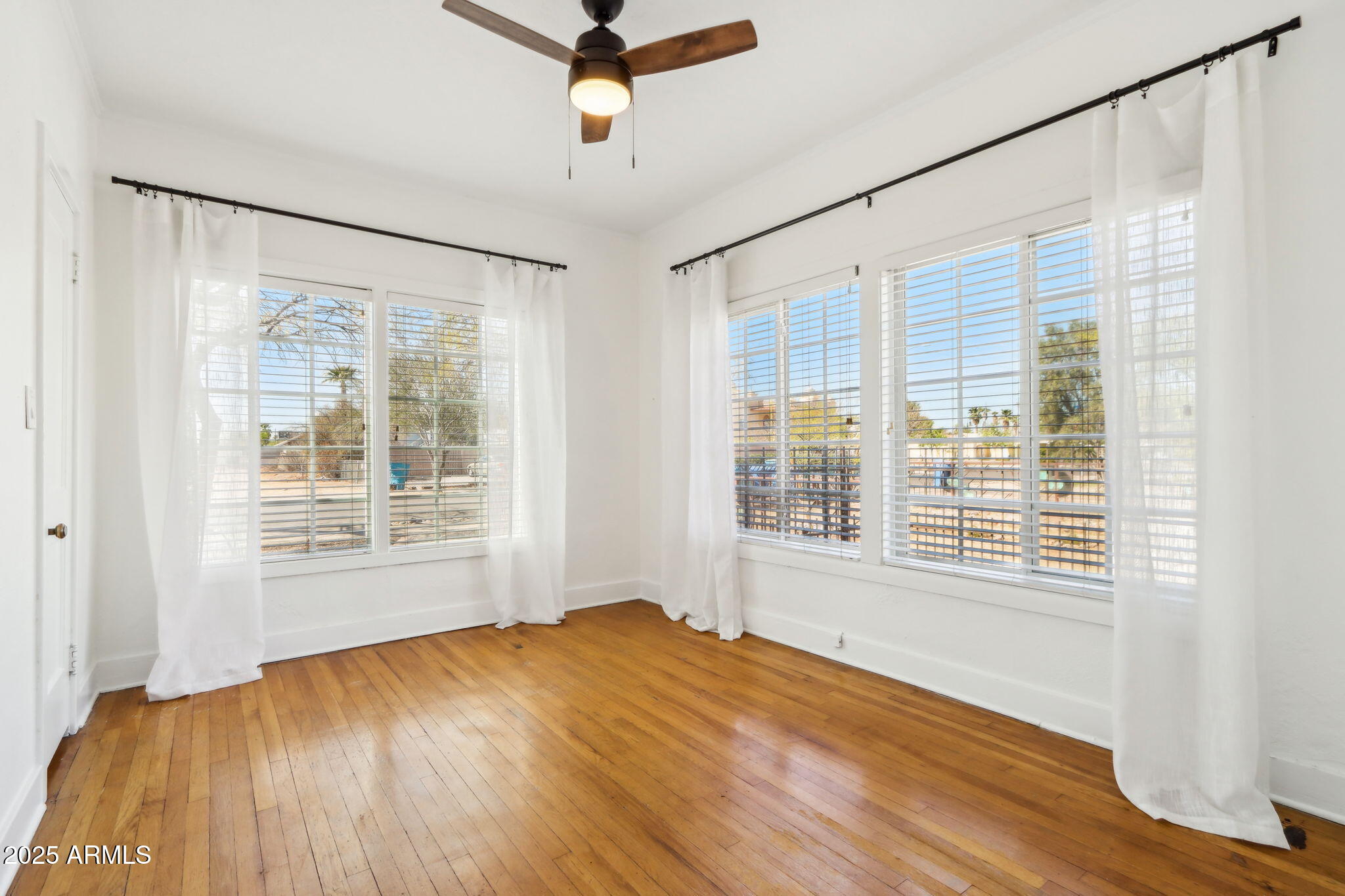 2237 North 9th Street Phoenix, AZ 85006 - Photo 15 of 29 a view of an empty room with a window and wooden floor