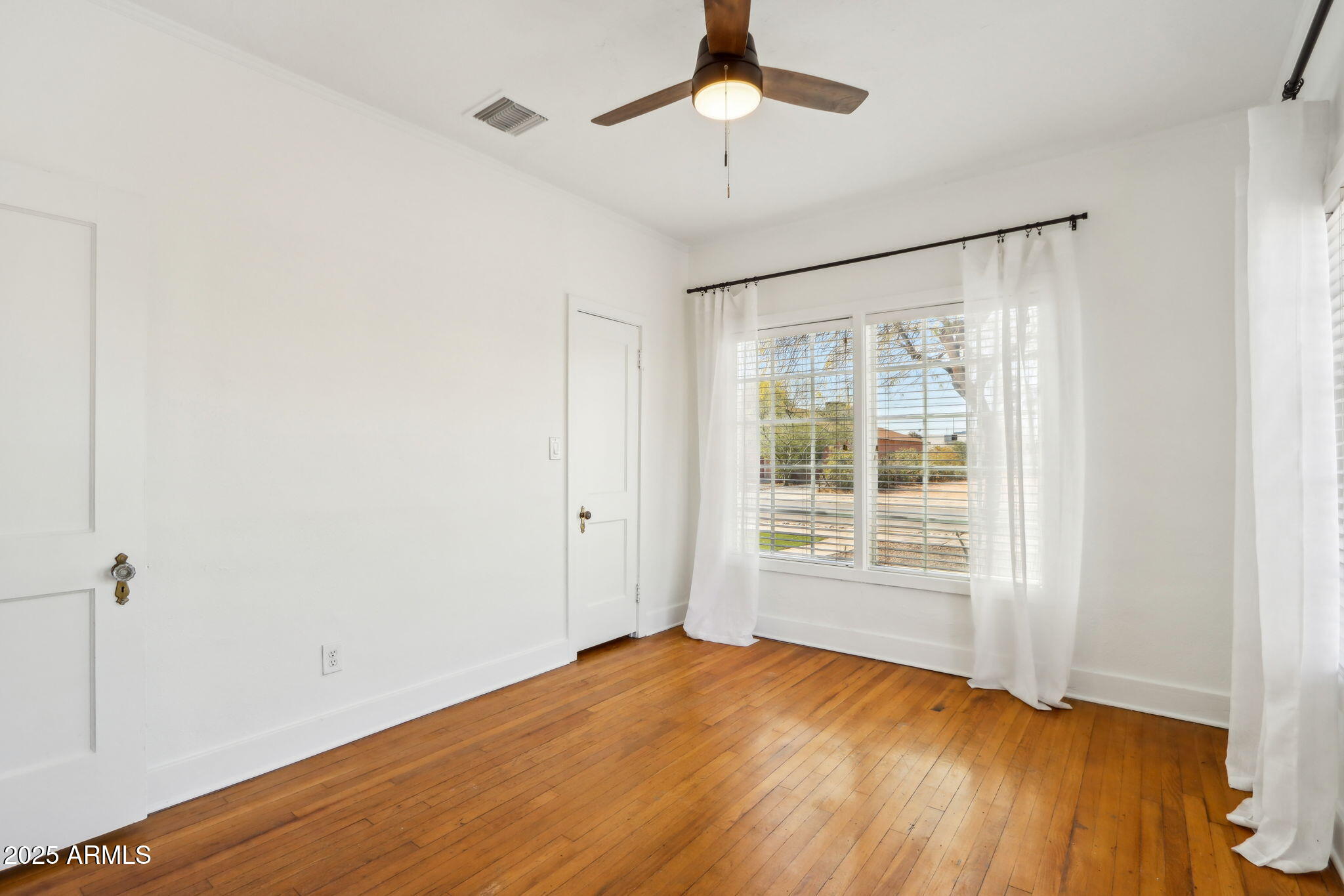 2237 North 9th Street Phoenix, AZ 85006 - Photo 16 of 29 a view of an empty room with a window and wooden floor