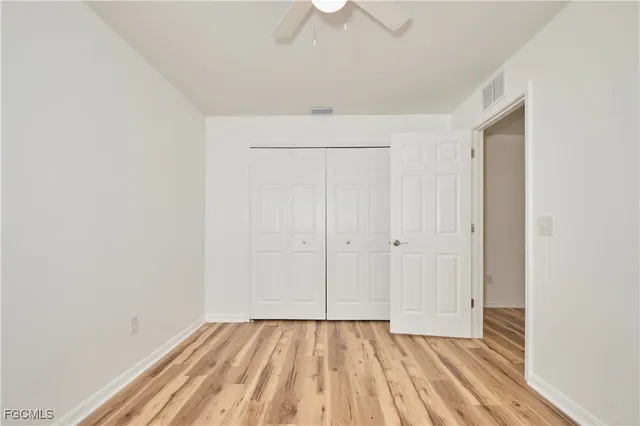 a view of an empty room and chandelier fan