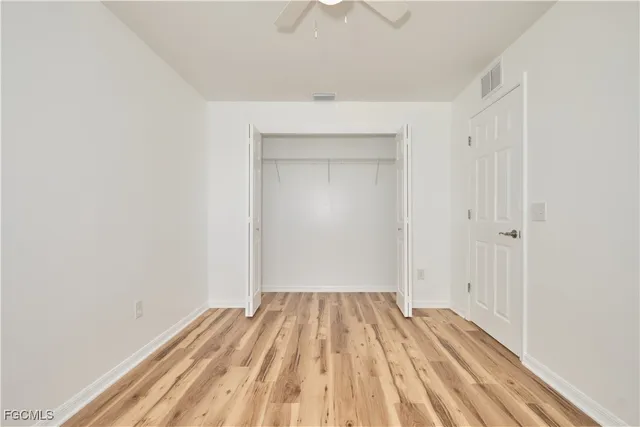 a view of a room with wooden floor and a ceiling fan