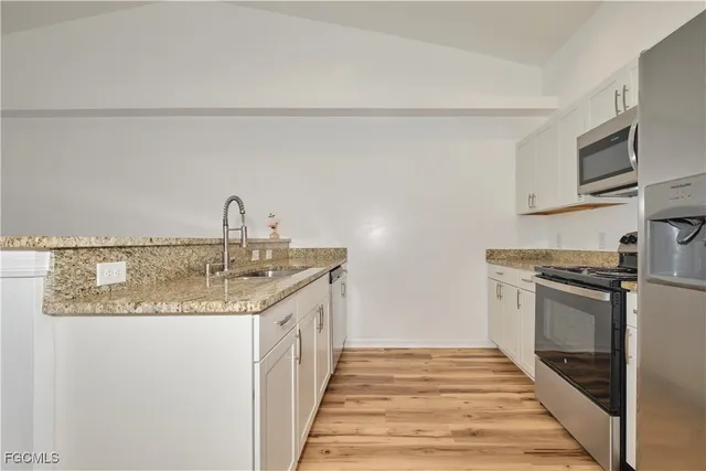a kitchen with stainless steel appliances granite countertop a sink and a stove