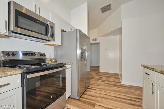 a kitchen with stainless steel appliances granite countertop a stove microwave and refrigerator