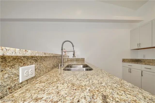 a close view of a sink a counter space and a stove in the kitchen