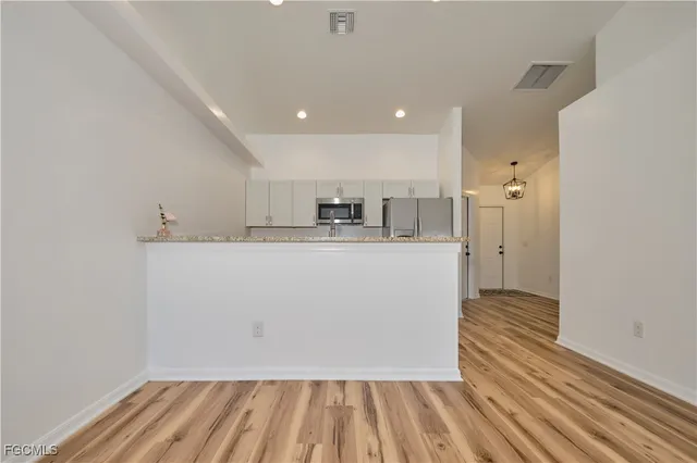 a view of kitchen with wooden floor and electronic appliances