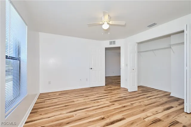 a view of a room with wooden floor and fan