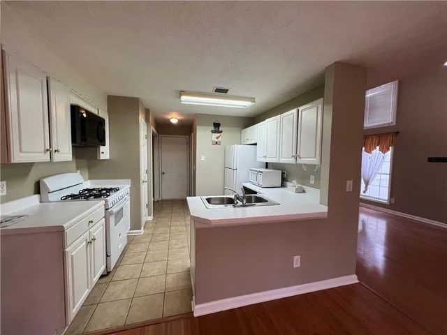 a kitchen with stainless steel appliances a sink stove top oven and refrigerator